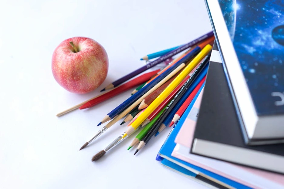 A collection of educational books and a tablet on a desk.